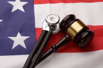 A gavel and a stethoscope on an American flag background, symbolizing a legal decision related to healthcare.