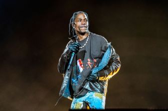 Travis Scott performing on stage at a concert.