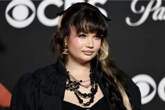 A close-up of British singer-songwriter Lola Young at a public event, showcasing her unique fashion and style.