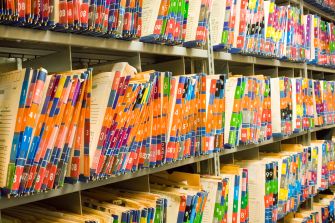 Color-coded and labeled medical files organized in a storage area.