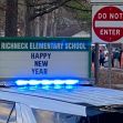 Sign outside Richneck Elementary School displaying "HAPPY NEW YEAR" with police presence in the foreground. Sign outside Richneck Elementary School displaying "HAPPY NEW YEAR" with police presence in the foreground.