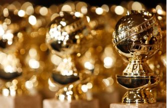 Golden Globes trophies displayed in a row, reflecting light.