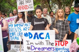 Protesters holding signs supporting DACA and Dreamers during a rally.