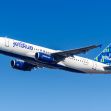 A JetBlue Airways airplane in flight against a clear blue sky. A JetBlue Airways airplane in flight against a clear blue sky.