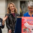 A group of people at a public event, with one woman speaking at a podium displaying a sign that reads "EQUAL PAY CALIFORNIA." A group of people at a public event, with one woman speaking at a podium displaying a sign that reads "EQUAL PAY CALIFORNIA."
