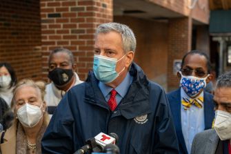 New York City Mayor Bill de Blasio speaks to the media about the lack of reliable internet access for children in homeless shelters during distance learning, surrounded by community members and advocates.