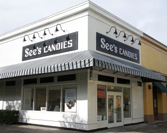 Image of a See's Candies store front, featuring the business's signage and an awning.