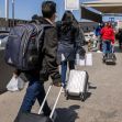 People walking with luggage towards an immigration checkpoint. People walking with luggage towards an immigration checkpoint.