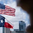 Image of the U.S. and Texas flags flying in front of a city skyline. Image of the U.S. and Texas flags flying in front of a city skyline.
