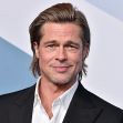 Brad Pitt smiling at a public event, wearing a black suit. Brad Pitt smiling at a public event, wearing a black suit.