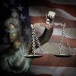 A representation of Lady Justice holding scales against the backdrop of the American flag, symbolizing the judicial system. A representation of Lady Justice holding scales against the backdrop of the American flag, symbolizing the judicial system.
