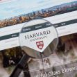 A magnifying glass focusing on the Harvard University logo displayed on a website. A magnifying glass focusing on the Harvard University logo displayed on a website.