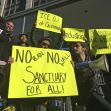 Protesters hold up signs outside a courthouse in San Francisco, file photo, April 14, 2017.