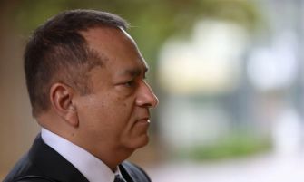 Close-up profile of Ramesh ‘Sunny’ Balwani, former Theranos executive, outdoors in a suit.