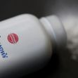 Container of Johnson's baby powder with a dusting of powder on a surface. Container of Johnson's baby powder with a dusting of powder on a surface.