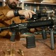 A person assembling a firearm with ammunition displayed on a table in a gun store or workshop. A person assembling a firearm with ammunition displayed on a table in a gun store or workshop.