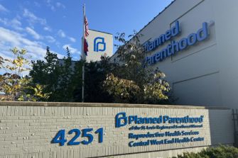 Sign outside a Planned Parenthood health center, indicating services provided and the center's location.