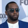 Image of Sean "Diddy" Combs wearing sunglasses and a suit at a public event. Image of Sean "Diddy" Combs wearing sunglasses and a suit at a public event.