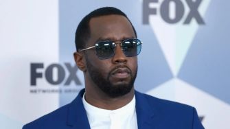 Image of Sean "Diddy" Combs wearing sunglasses and a suit at a public event.
