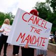 A group of protesters hold signs opposing the COVID-19 vaccination mandate at Indiana University. A group of protesters hold signs opposing the COVID-19 vaccination mandate at Indiana University.