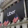 Exterior view of the New York Stock Exchange featuring a large Uber banner and American flags. Exterior view of the New York Stock Exchange featuring a large Uber banner and American flags.