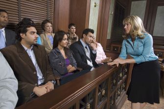 A diverse jury seated in a courtroom, listening to an attorney during a trial.