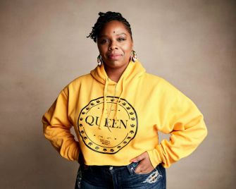 Patrisse Khan-Cullors, co-founder of the Black Lives Matter movement, poses in a yellow hoodie with the word "QUEEN."
