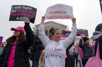 Demonstrators holding signs in support of Planned Parenthood outside the Supreme Court during a protest.