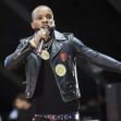 Tory Lanez performing on stage, wearing a black leather jacket and holding a microphone. Tory Lanez performing on stage, wearing a black leather jacket and holding a microphone.