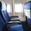 Image of airplane seats with limited legroom viewed from the aisle. Image of airplane seats with limited legroom viewed from the aisle.