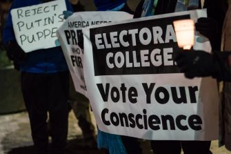 Protesters holding signs advocating for the Electoral College and urging people to vote their conscience.