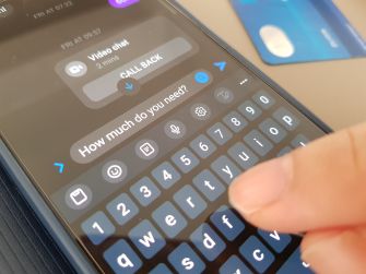 A smartphone screen displaying a chat interface with a finger typing the message, "How much do you need?"