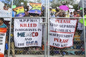 Demonstrators holding signs protesting the Migrant Protection Protocols (MPP), highlighting its impact on immigrants in Mexico and the USA.