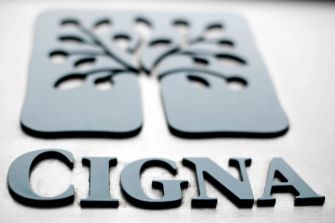 Cigna logo displayed on a metallic surface with a tree design in the background.