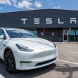 Tesla vehicle parked in front of a Tesla factory building. Tesla vehicle parked in front of a Tesla factory building.