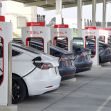 A row of Tesla vehicles charging at a Tesla Supercharger station. A row of Tesla vehicles charging at a Tesla Supercharger station.