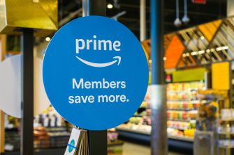 Sign advertising Amazon Prime membership benefits in a grocery store setting.