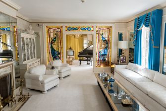 Interior view of Graceland, featuring a grand piano, decorative windows, and elegant furnishings.
