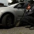A police officer inspecting the wheel of a vehicle during a search. A police officer inspecting the wheel of a vehicle during a search.