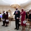 Participants, including President Biden and First Lady Jill Biden, standing with hands over their hearts during an event in the White House, with a video screen in the background. Participants, including President Biden and First Lady Jill Biden, standing with hands over their hearts during an event in the White House, with a video screen in the background.