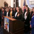 A group of women standing together at a press conference advocating for survivors' rights, with a banner reading "Justice for Survivors" in front of them. A group of women standing together at a press conference advocating for survivors' rights, with a banner reading "Justice for Survivors" in front of them.