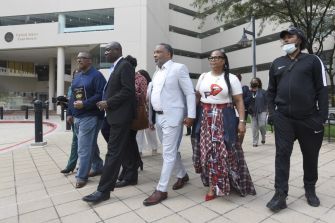 A group of individuals walking together outside a courthouse, likely in relation to the lawsuit filed by the family of Henrietta Lacks.