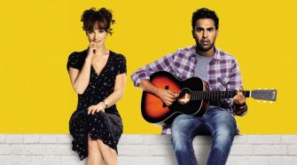 A scene from the movie "Yesterday," featuring two characters: one sitting and thinking, and the other playing an acoustic guitar against a bright yellow background.