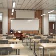 A classroom with empty desks and a whiteboard at the front. A classroom with empty desks and a whiteboard at the front.