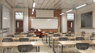 A classroom with empty desks and a whiteboard at the front.
