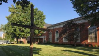 Image of the Martin Luther King Jr. Community Presbyterian Church, with a cross in the foreground and the church visible in the background.