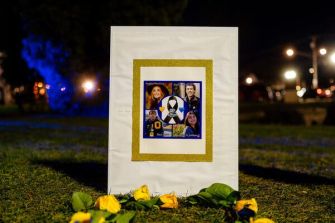 Memorial display honoring victims of a school shooting, featuring photos and flowers.