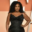 Lizzo posing in a black fashion outfit at a public event. Lizzo posing in a black fashion outfit at a public event.