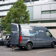 Amazon delivery van parked in a lot, with the back door open, surrounded by trees and nearby buildings. Amazon delivery van parked in a lot, with the back door open, surrounded by trees and nearby buildings.