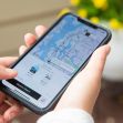 A person holds a smartphone displaying the Uber app's map and ride options. A person holds a smartphone displaying the Uber app's map and ride options.